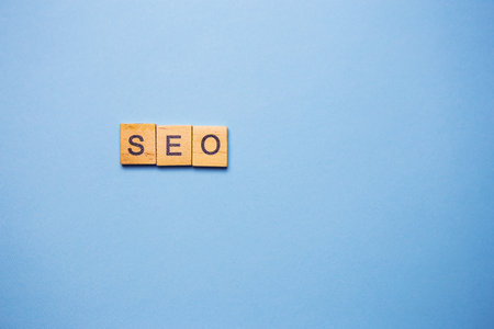 Wooden letters SEO printed on a light blue backgroundの写真素材