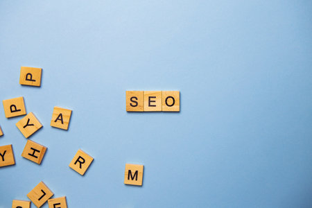 Wooden letters SEO are printed on a light blue background with many different wooden letters in the backgroundの写真素材