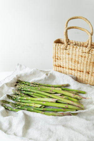 Fresh sliced asparagus on a white background. view from above. Vegan and very healthy healthy food. Farmer's harvest, going to the market. Straw basketの写真素材