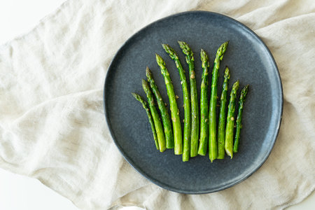 Close-up on a large plate - asparagus with salt and garlic. Delicious and healthy food, served in a restaurant, beautiful layoutの写真素材