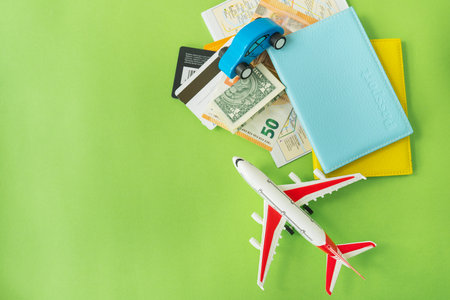 Composition from a city map with a bank card, euro, dollar banknotes, passports and a toy plane on a green background. travel and vacation conceptの写真素材