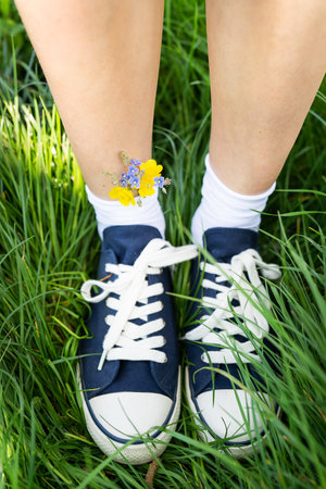 Beautiful casual shoes with flowers in socks. Flowers in blue sneakers, a classic. walk. Modern unisex shoes. Fashionable stylish sports casual shoes. high quality photoの写真素材