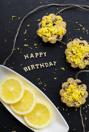 lemon cupcakes on a black background - inscription happy birthdayの写真素材