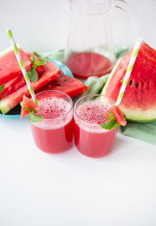 Juicy fresh watermelon juice in a glass along with a green tube, delicious and healthy summer foodの写真素材