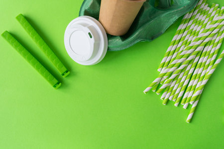 Plastic and recycling concept, closeup top view. Green background with glass, tubes, bag clip, stand, lidの写真素材