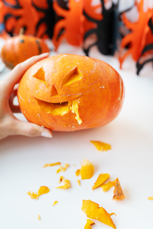 October 31. Halloween holiday. The carved face of a pumpkin on an orange and black backgroundの写真素材