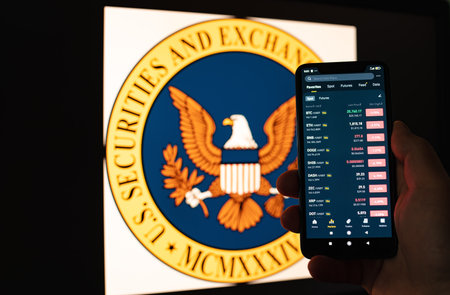Kyiv, Ukraine - 06 June 2023: Man holds a smartphone with cryptocurrency quotes on Binance against the background of monitor with the SEC . SEC Accuses Binance - fall of cryptocurrenciesのeditorial素材