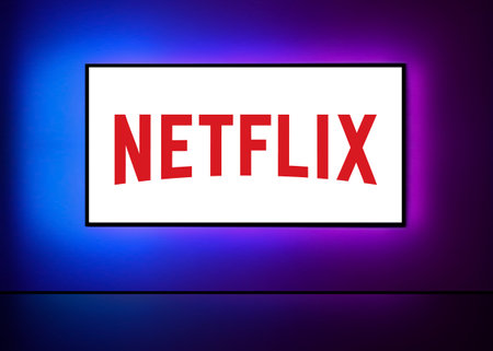 Kyiv, Ukraine - 10.08.2023: Netflix on the big TV screen with neon colorful background on wall. Netflix is an American entertainment company founded by Hastings and Randolph. vector illustrationのeditorial素材