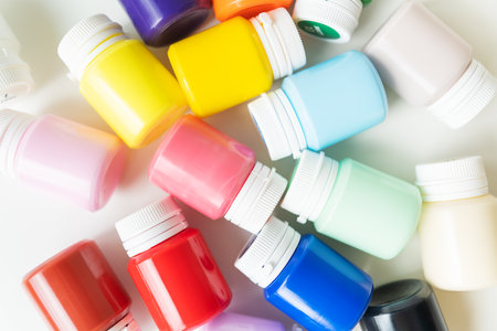 Jars of multi-colored bright acrylic paints isolated on a white background. Close-up, hobby, artist, drawing processの写真素材