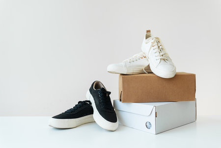 Two pairs of comfortable shoes in black and white stand on the table. Two boxes with new comfortable shoes for an active lifestyle, fitness and sports. Online shopping conceptの写真素材
