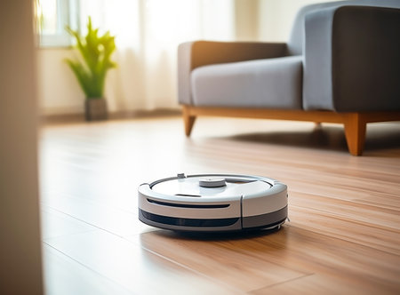 A modern robot vacuum cleaner works in a modern room. Works remotelyの素材