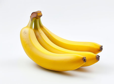 A bunch of ripe bananas on a white background, perfect for a clean, fresh lookの素材