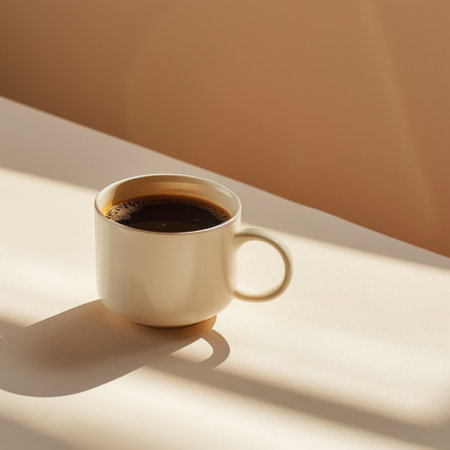 A warm cup of coffee bathed in soft sunlight, casting gentle shadows, creating a serene and cozy atmosphereの素材