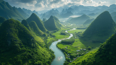 The sun casts a golden glow over karst mountains, highlighting the winding river and lush rice paddies belowの素材
