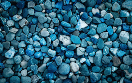 A stunning collection of smooth, polished pebbles in various shades of blue, creating a captivating and serene natural patternの素材