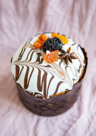 A delicious Easter cake, adorned with a marbled chocolate and white icing, is decorated with dried fruits and spices. It's a festive treat perfect for the holiday.の写真素材