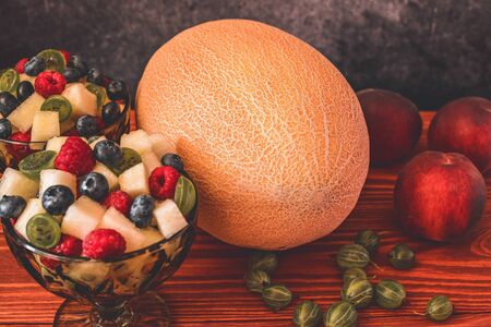 Melon on wooden table with black backgroundの写真素材