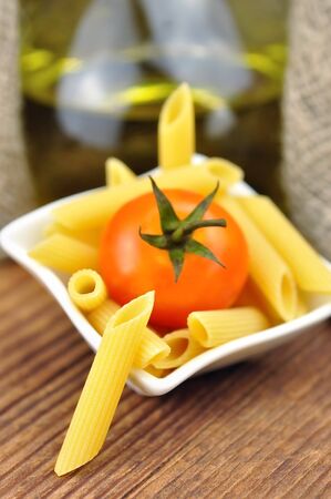 Raw penne pasta in a small bowl, selective focusの写真素材