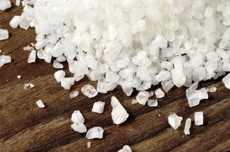 Coarse salt on a old wooden table, closeupの写真素材