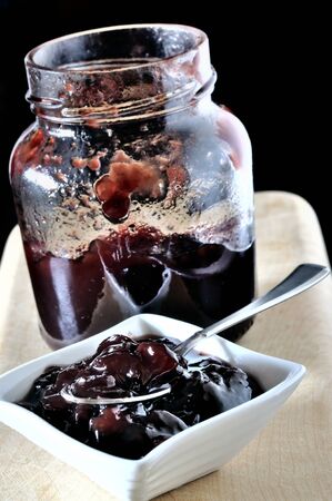 Small bowl and jar of cherry jamの写真素材
