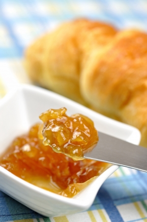 Orange jam and fresh croissant on a tablecloth, selective focusの写真素材