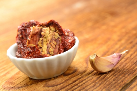 Sun dried tomatoes on a wooden chopping board, selective focusの写真素材