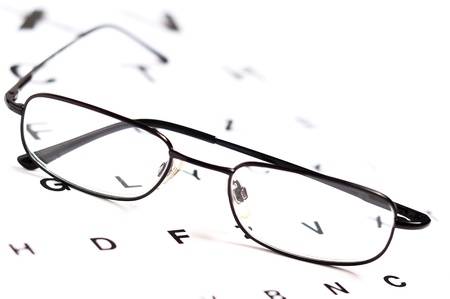 Eyeglasses over eye chart, closeup