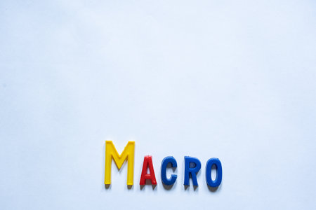 The word MACRO is created by arranging a set of 3D colorful plastic English alphabet letters against...