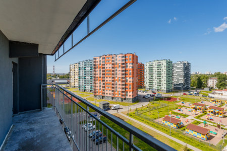 Bright multi-story buildings of a new residential complex are visible from a balcony on a sunny day. Urban landscape.の写真素材