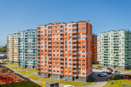 A row of bright multi-story buildings in a modern residential complex under a clear blue sky. Urban landscape.の写真素材