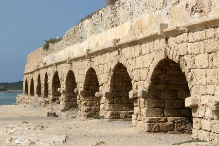 The ruins of this ancient Roman aqueduct were built along the coast of the Mediterranean Sea. It used gravity to bring water from the mountains into the cities of Israel during the time of Christ.の写真素材