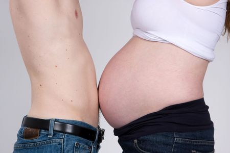 A man touches his stomach to his pregnant wife's  stomach.