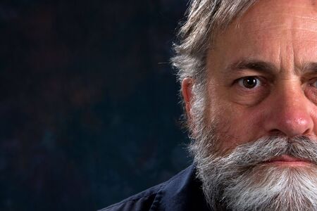 Serious look on a mature man's half face. Room for copy on left.の写真素材