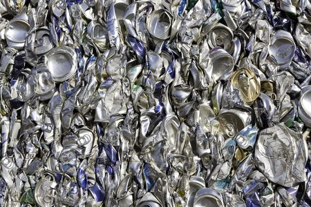 Crushed aluminum cans compressed together wait to be recycled.の写真素材