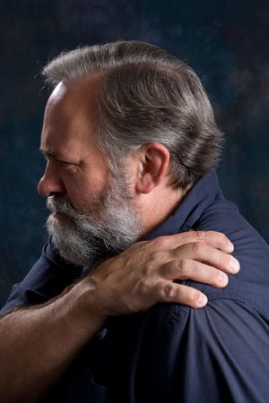 Man massages his painful shoulder.の写真素材