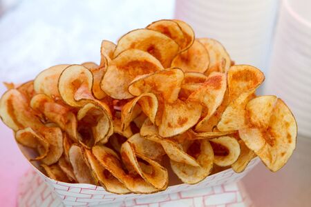 Hot butterfly fries sit in a vendors window ready to be bought and eaten.の写真素材