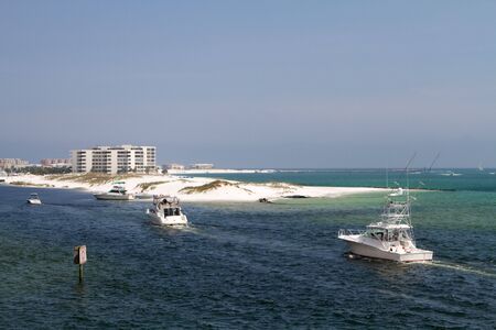 Charter fishing boats enter Destin Harbor, Florida.の写真素材