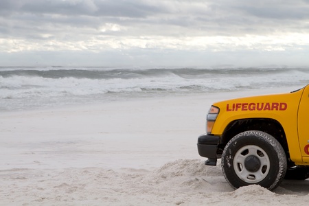 Lifeguard truck is parked on the beach as tropical storm generated waves come ashore to warn swimmers about the dangerous surf.の写真素材