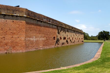 Moat and exterior walls of Fort Pulaski National Monument on Cockspur Island in the Savannah River, Georgia, USA. Holes were made by Union canon fired from Tybee Island during the Civil War.のeditorial素材