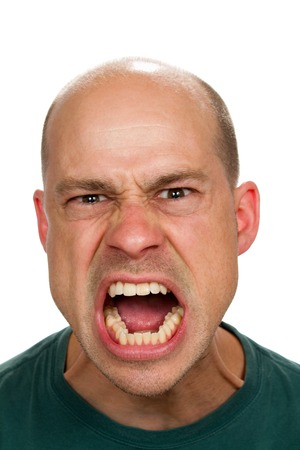 Angry and mad man screams with his mouth wide open showing his rage.