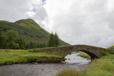 The old bridge over the slow stream Scottishの写真素材