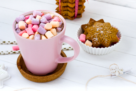 Christmas cocoa marshmallow pink cup and ginger biscuit white wooden tableの写真素材