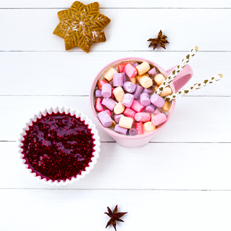 Christmas cocoa with marshmallow in a pink cup and ginger biscuit on a wooden tableの写真素材