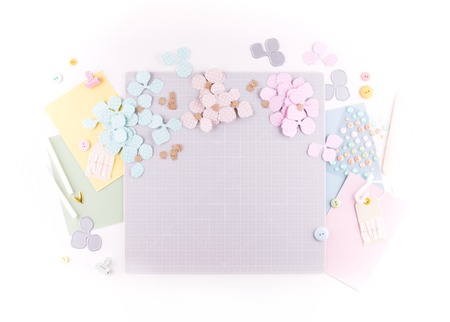 Flat lay, top view craft table desk. Workspace with mat for cutting, scissors, cardstock, paper, pencils on white background. Make floral wreath decor.の写真素材