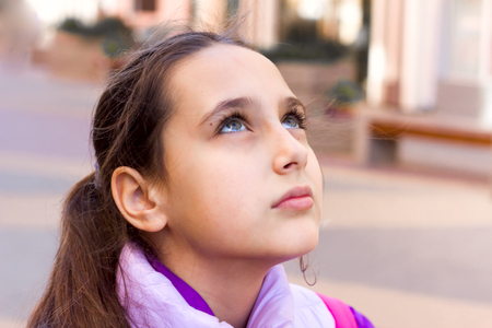 Teenager emotions - dreaminess. Schoolgirl on town streetの写真素材