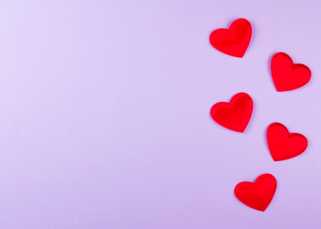 Red hearts, purple background, valentine's day decor. Top view. Copy spaceの写真素材
