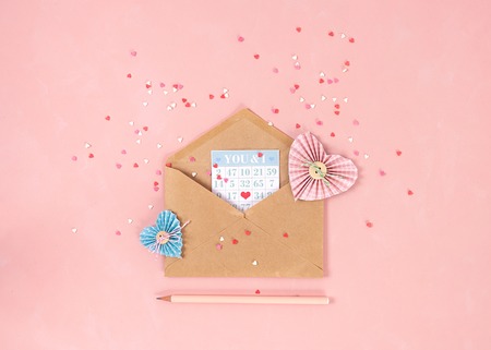 Paper hearts in scrapbooking technique and pink and red sweets sugar candy hearts fly out of craft...