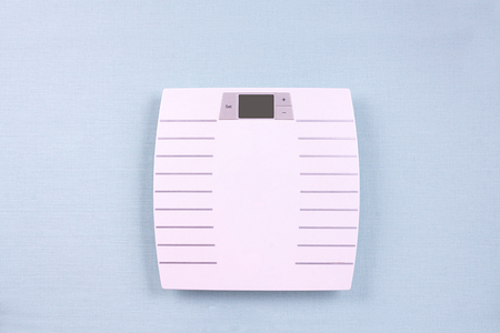 Flat lay singl scales on blue background. Weight loss concept. Top viewの写真素材