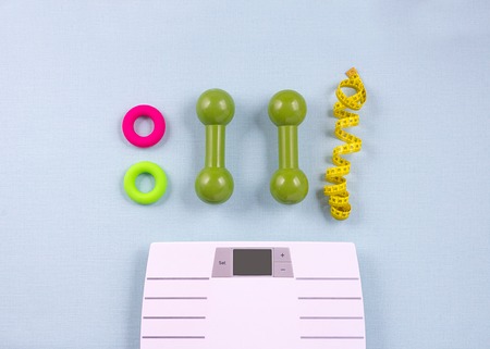 Flat lay composition with sport items, scales on blue background. Weight loss concept. Top viewの写真素材