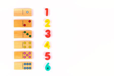 Colored dominoes and numbers on a white background. Learning mathematics of children at school, preschool,kindergarten. Educational concept. Flat lay. Copy spaceの写真素材